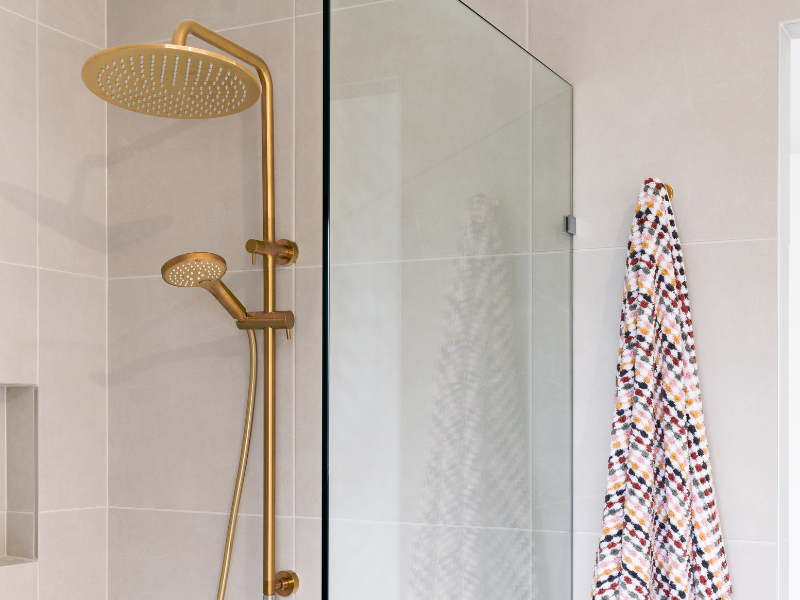 Gold showerhead and towel on hook