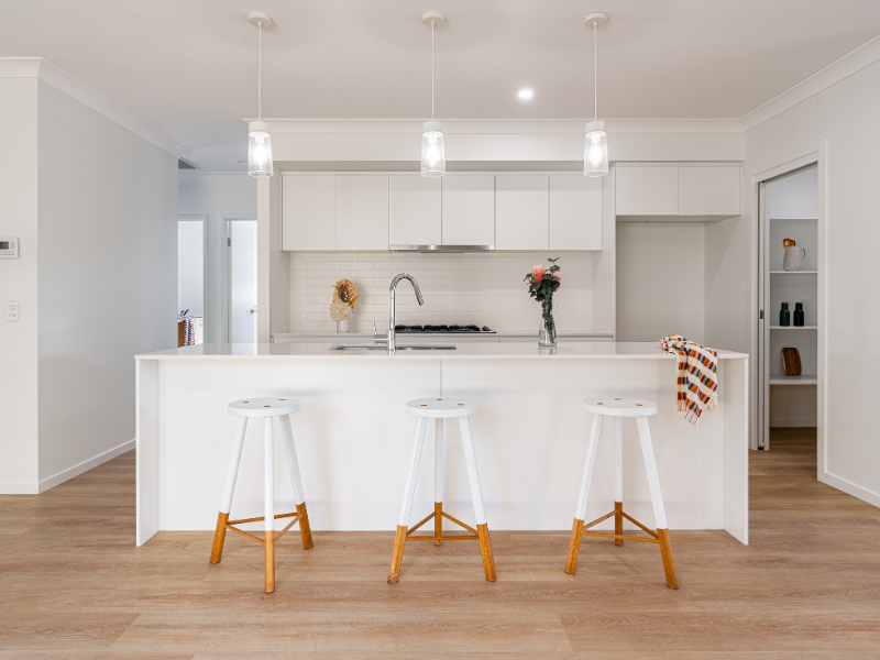 Minimalist kitchen with feature lighting & stools