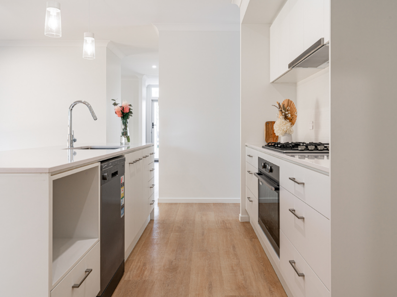 White kitchen with timber-looking vinyl flooring 