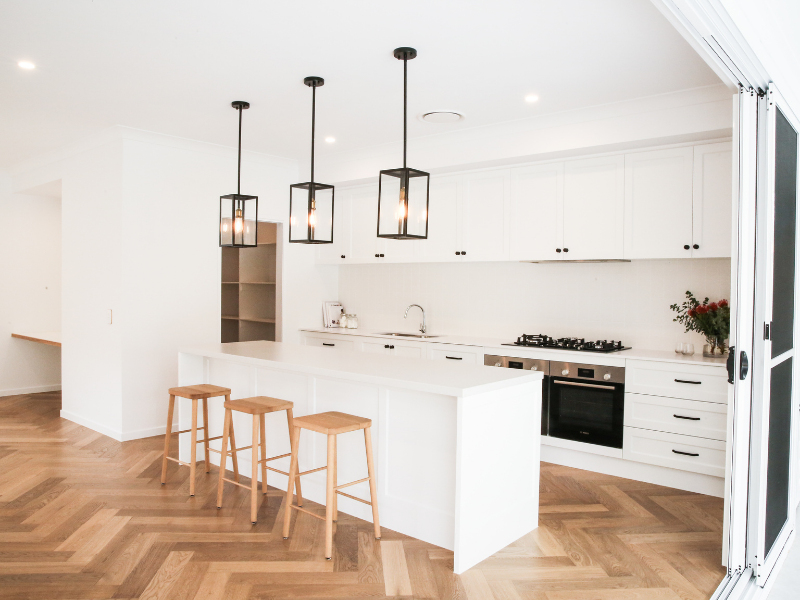 Contemporary and monochrome kitchen with geometric pendants over the kitchen bench
