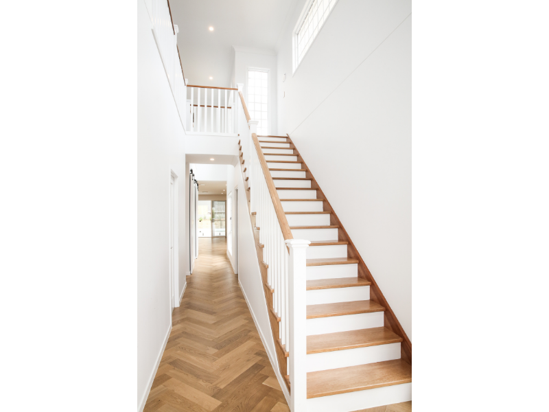 Striking staircase and hallway with timber and white features